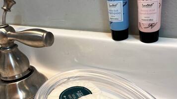 A bathroom sink with two TravelWell products and two soap bars.