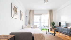 Un dormitorio moderno con cama, mesita de noche y televisor.