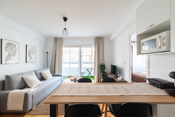Un salon moderne avec un canapé, une table à manger et un téléviseur.