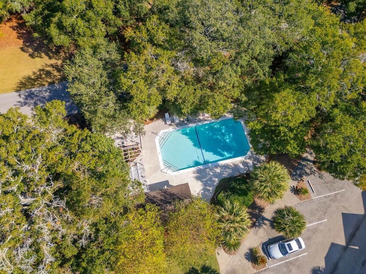 Vue aérienne d’une propriété dotée d’une piscine entourée d’arbres.
