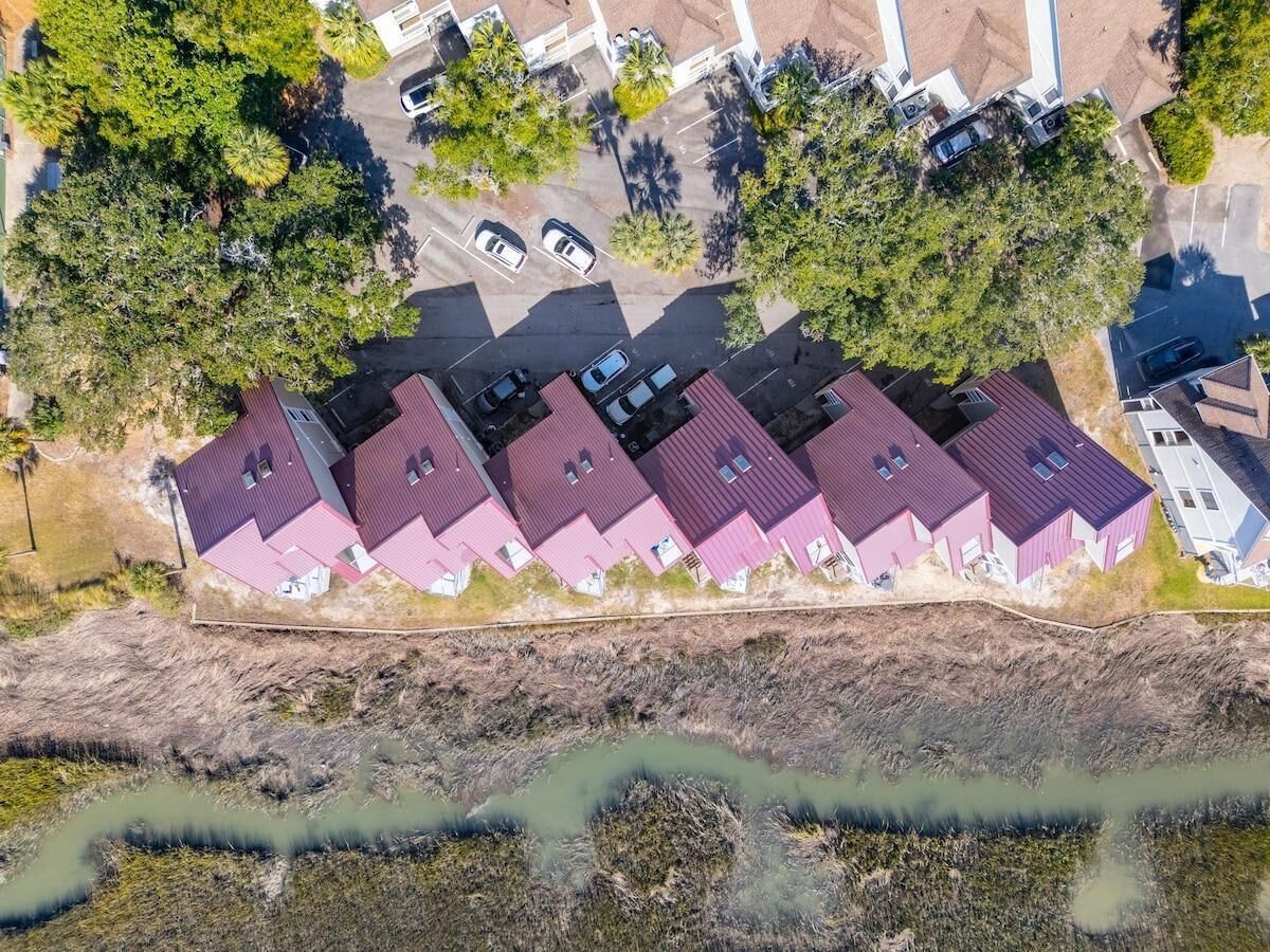 Vista aérea de una zona residencial con varias casas, un estacionamiento y una masa de agua.