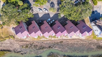 Vista aérea de una zona residencial con varias casas, un estacionamiento y una masa de agua.