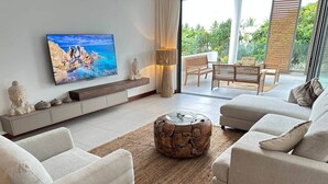A modern living room with a flat-screen TV, a stone coffee table, and a sofa set.