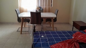 A room with a bed, a small table, and two chairs. - The Hidden One (Praia)