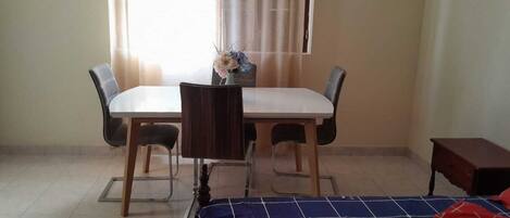 A room with a bed, a small table, and two chairs.