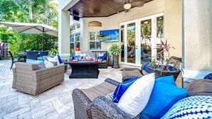 An outdoor patio with wicker furniture, a coffee table, and potted plants. - 5 Bedroom Luxury Home, Minutes to Las Olas, Shops & Beach (Fort Lauderdale)