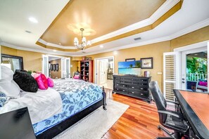 Une chambre à coucher comprenant un lit, un bureau, une chaise, une commode et un téléviseur.