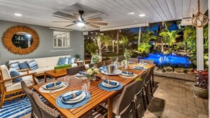 A dining area with a wooden table set for six, surrounded by wicker chairs. A ceiling fan is visible above the table, and a large mirror hangs on the wall. - New Waterfront Oasis, Minutes to Beach, Eats, Shops (Fort Lauderdale)