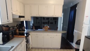 A kitchen with white cabinets, a black and beige patterned rug, and a tiled floor. - Spacious 4BR/2.5BA•Pet-Friendly•Safe Charlotte Location Near Uptown & SouthPark! (Charlotte)
