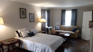 A hotel room with a bed, a sofa, a table, and a lamp. - Spacious 4BR/2.5BA•Pet-Friendly•Safe Charlotte Location Near Uptown & SouthPark! (Charlotte)