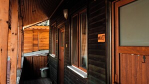 A wooden cabin with a porch, a window with a number sign, and a door. - Abant Barış Pension (Bolu)