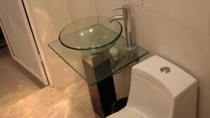 A bathroom with a glass sink, a toilet, and a mirror. - HOTEL CALLE 8 (Tuxtla Gutierrez)