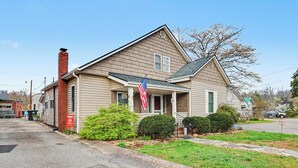 A single-story house with a front porch, a chimney, and a small front yard with a flag. - Near Murphy River Walk: Historic Downtown Home! (Murphy)