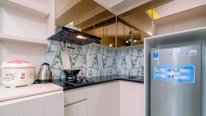 Une cuisine moderne équipée d’un réfrigérateur en acier inoxydable, d’une cuisinière à gaz et d’un four à micro-ondes.