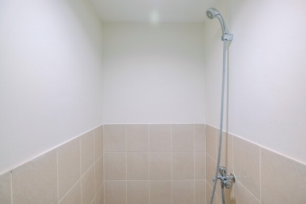 A shower with a handheld showerhead and a flexible hose, tiled walls, and a corner shower area. - Cozy Living and Relaxing Podomoro Golf View 2BR Apartment (Gunung Putri)