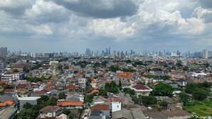 A cityscape with dense residential buildings and a distant skyline of high-rise buildings. - Cozy Studio at Belmont Residence Puri Apartment (Jakarta)