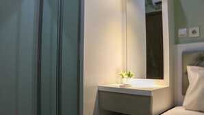 A modern bathroom with a white sink, a mirror, and a small potted plant. - Spacious and Good 2BR at Podomoro Golf View Apartment (Gunung Putri)