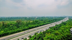 A highway with multiple lanes and vehicles, surrounded by dense green trees and vegetation. - Nice and Comfort Studio at 25th Floor Podomoro Golf View Apartment (Gunung Putri)