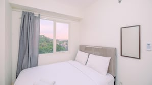 Una cama bien hecha con sábanas blancas, una ventana con cortinas y un interruptor de luz en la pared.