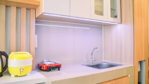 A modern kitchen with a sink, a countertop, and a cabinet above the sink. - Dashing Studio at Baileys Apartment (South Tangerang)