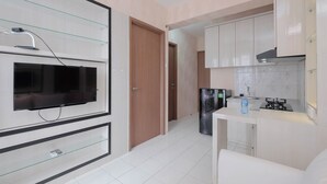 A modern kitchen with white cabinets, a built-in oven, and a refrigerator. - Comfort and Stylish 2BR at Podomoro Golf View Apartment (Gunung Putri)