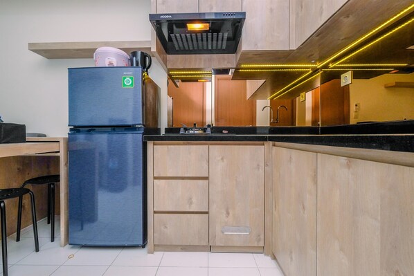 Una cocina moderna con refrigerador empotrado, armarios de madera y campana extractora de acero inoxidable.