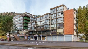 Ein mehrgeschossiges Gebäude mit modernem architektonischen Design, ausgestattet mit großen Fenstern und einer Kombination aus Backstein- und Glasfassaden.