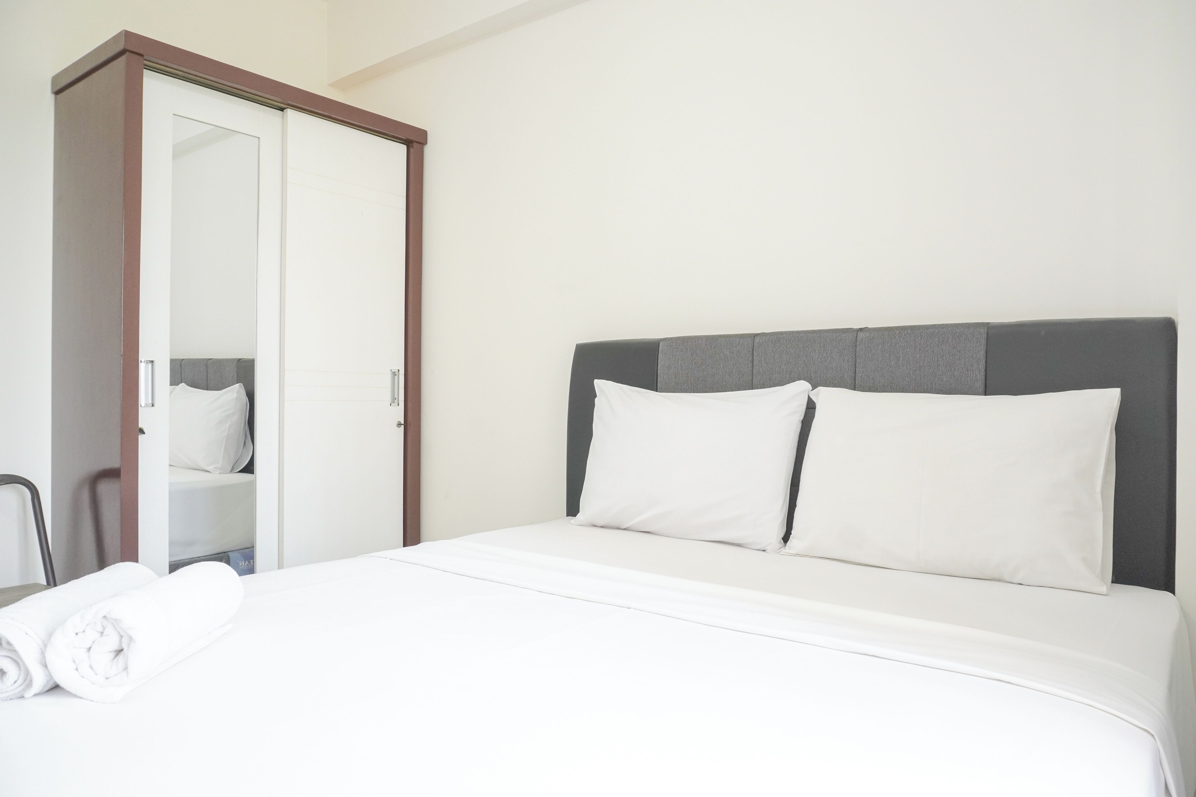 Une chambre d’hôtel avec un lit, une armoire et une chaise.
