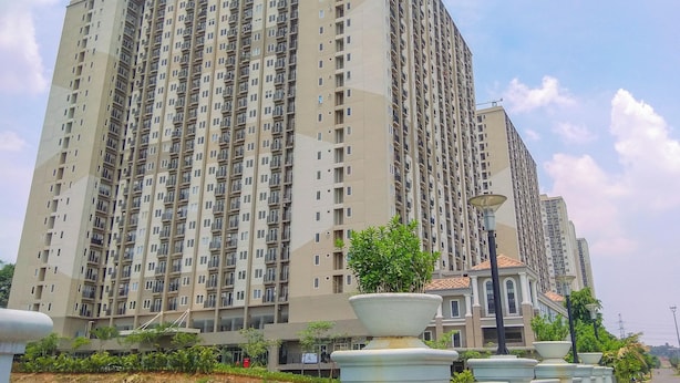 Un edificio residencial alto con varios balcones y el logotipo de PG a la vista.