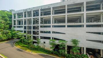 A multi-story parking garage with a curved road in front.