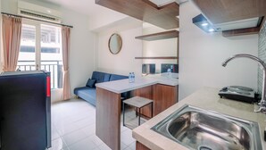 A compact kitchen with a built-in island, a sink, and a refrigerator.