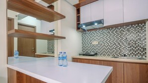 A modern kitchen with a white countertop, wooden cabinets, and a tiled backsplash.