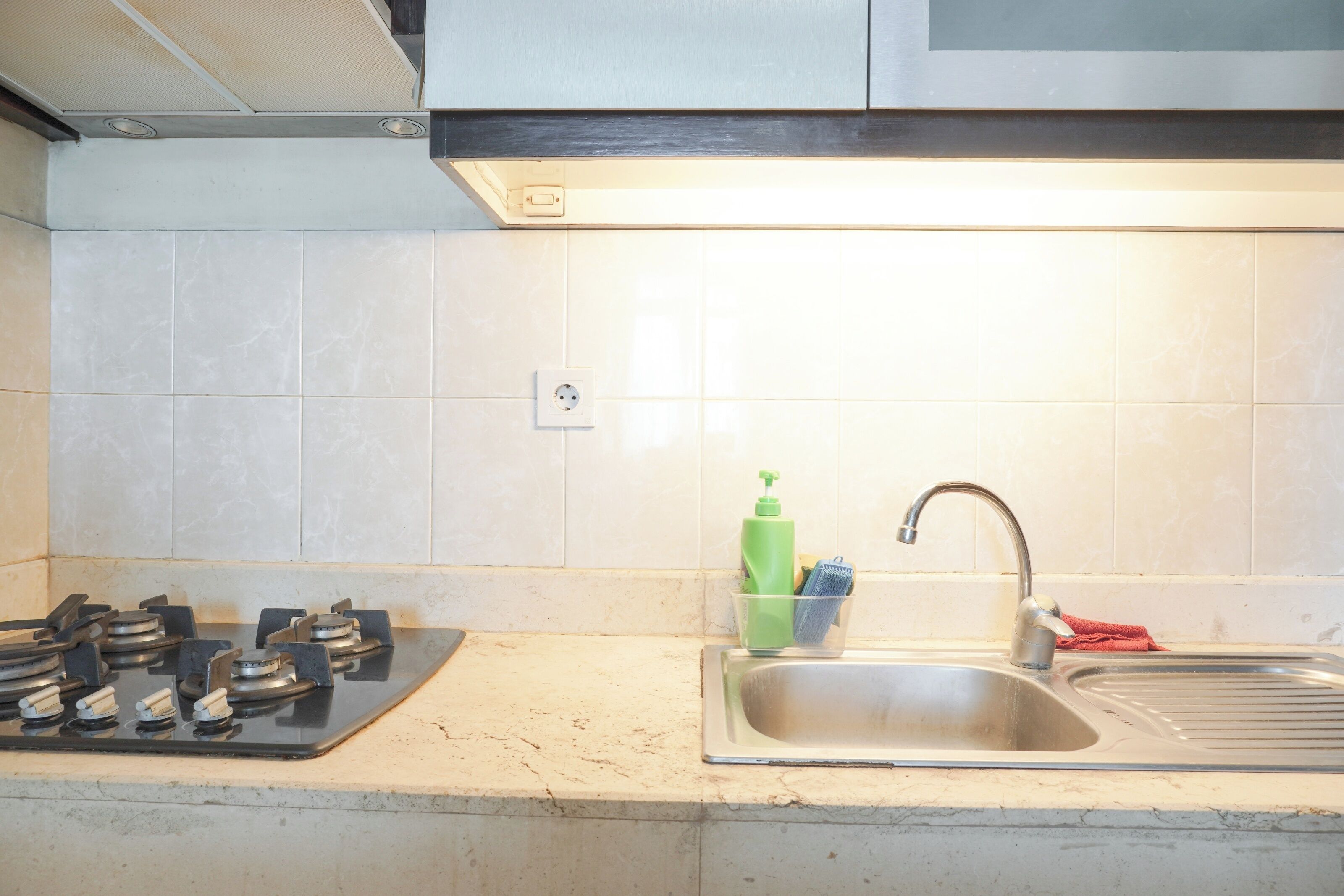 A kitchen with a gas stove, a sink, and a countertop.