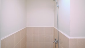 A small, enclosed shower area with a handheld showerhead and a fixed showerhead. - Comfort Stay 2BR at Podomoro Golf View Apartment (Gunung Putri)