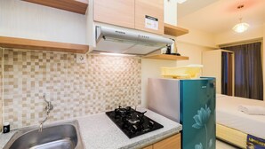 Una cocina moderna con estufa a gas, pileta de acero inoxidable y refrigerador.