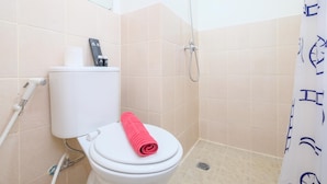 Ein Badezimmer mit Toilette, Dusche und Handtuchhalter.