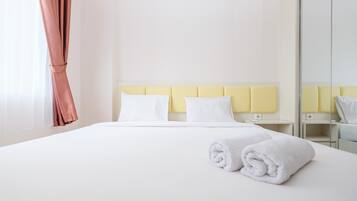 Une chambre d’hôtel avec un lit, deux tables de chevet, un miroir et une fenêtre avec des rideaux.