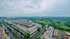 Un quartier résidentiel comprenant un grand ensemble d’immeubles, entouré de verdure et bordé par une rivière.