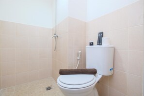 A bathroom with a toilet, a shower, and a towel rack. - Comfort 2BR at 6th Floor Podomoro Golf View Apartment (Gunung Putri)
