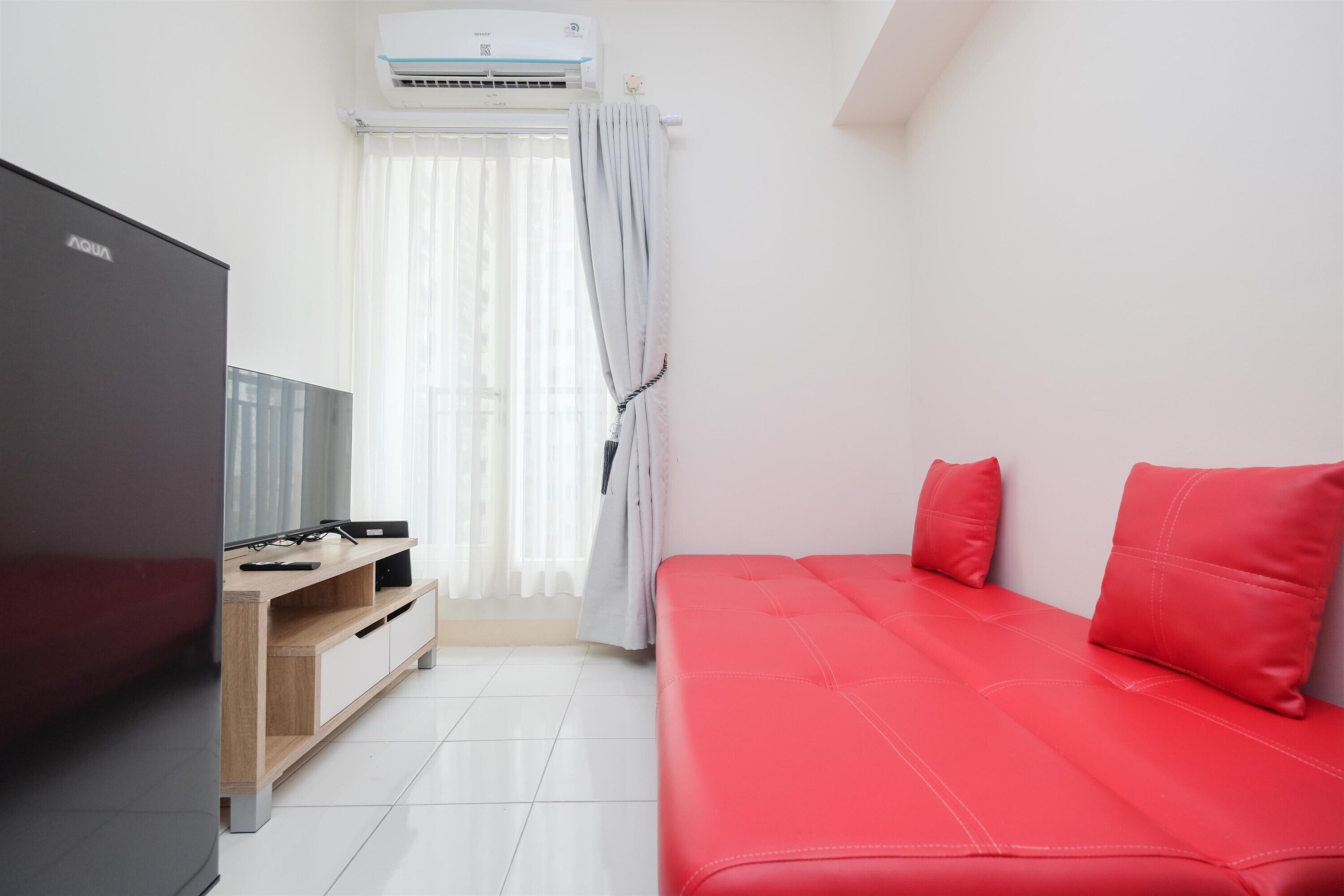 Ein Zimmer mit einem Bett, einem Fernseher und einem Holzschrank.