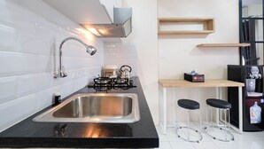 A modern kitchen with a stainless steel sink, gas stove, and a coffee machine.
