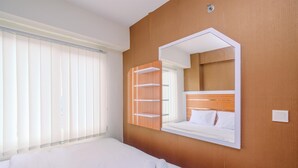 Una camera d'albergo con un letto, un ampio specchio e una finestra con persiane.