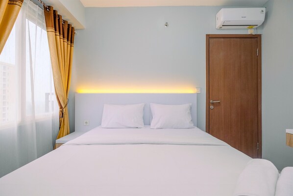 Simple, clean design with a single bed and air conditioning unit.