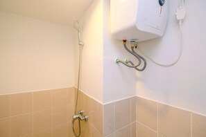 Enjoy a refreshing shower in this bathroom with a wall-mounted showerhead and control unit.