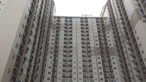 A high-rise residential building with multiple balconies and a uniform facade. - Brand New and Fresh Studio Podomoro Golf View Apartment (Gunung Putri)