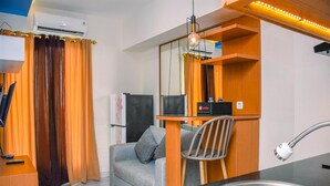 A compact kitchen with a sink, a chair, and a small table. - Nice and Warm 2BR at Podomoro Golf View Apartment (Gunung Putri)