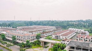 A residential area with modern apartment buildings, arranged in rows with a central green space. - Nice and Warm 2BR at Podomoro Golf View Apartment (Gunung Putri)
