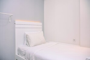 Simple, clean design with a single bed and a nightstand.