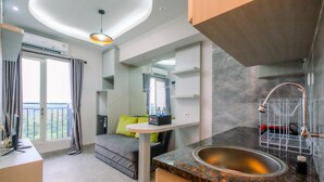 Une cuisine moderne équipée d’un évier, un coin repas avec une table et des chaises, et un balcon avec vue.
