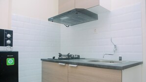A kitchen with a built-in stove, a sink, and a Sharp refrigerator.